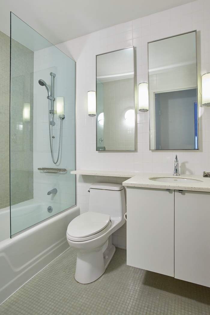40 East 94th Street, Unit 3D Manhattan, NY 10128 - Photo 4 of 5 a bathroom with a toilet a sink a shower and a mirror