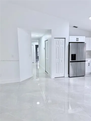 a view of a kitchen with a refrigerator and a stove top oven