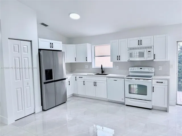 a kitchen with cabinets appliances and a window