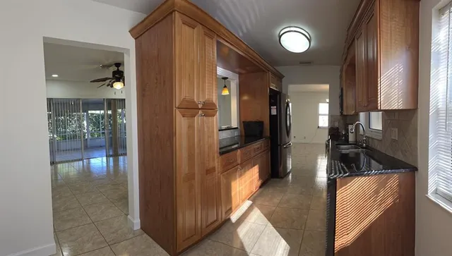 a kitchen with stainless steel appliances granite countertop a refrigerator and a sink