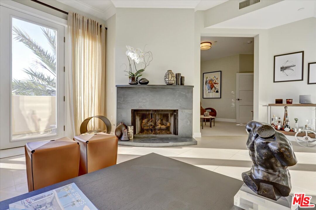 a living room with furniture a large window and a fireplace