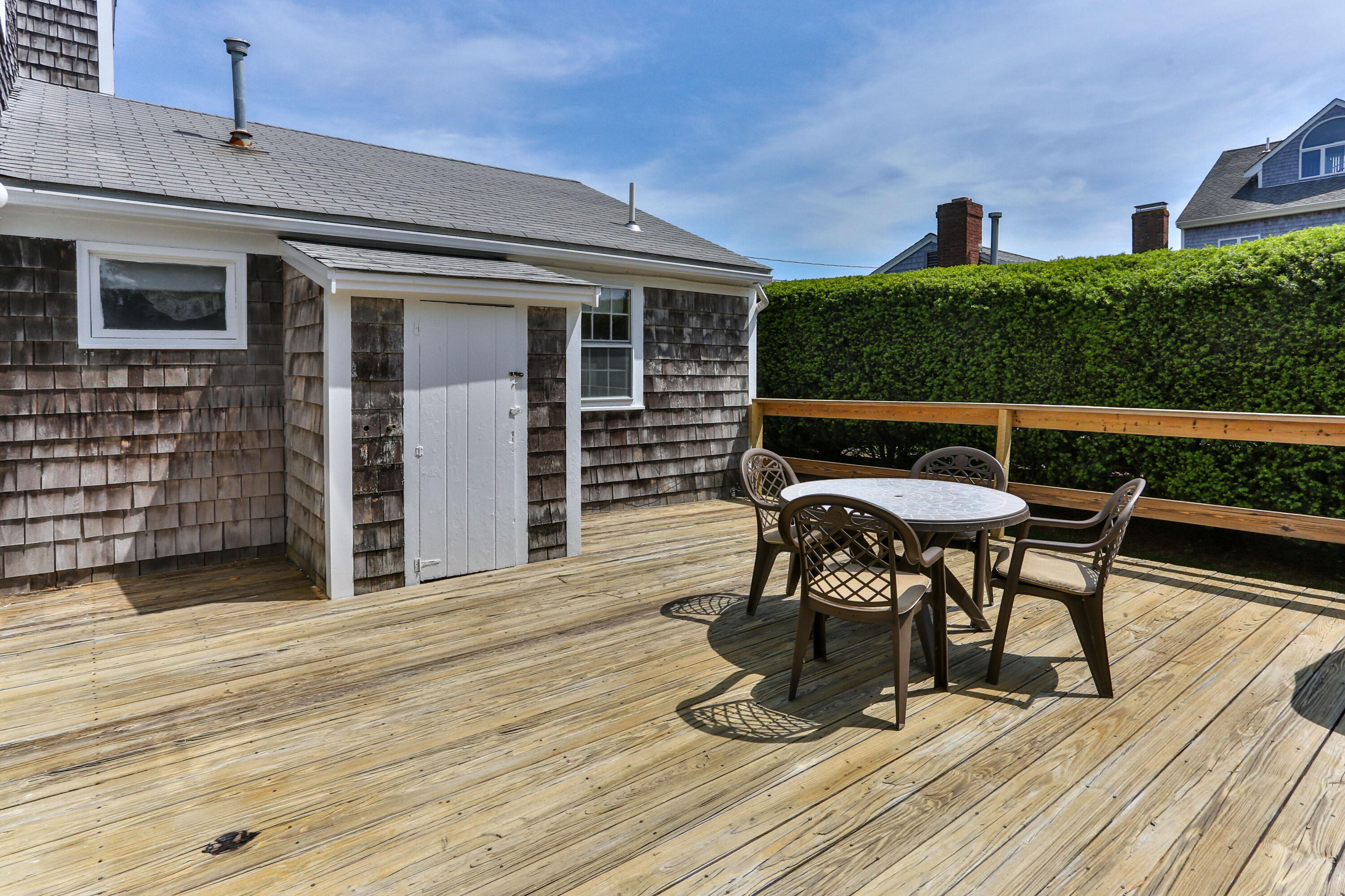 77 Susan Ruth Road Dennis Port, MA 02639 - Photo 21 of 25 a view of a patio with table and chairs with wooden floor and fence