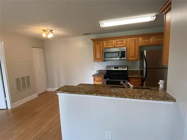 a kitchen with kitchen island a counter top space a sink and a refrigerator