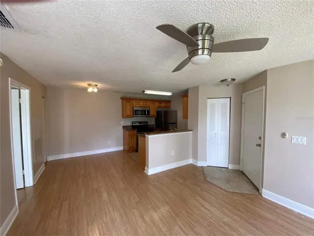 a view of kitchen with stainless steel appliances refrigerator stove and wooden floor