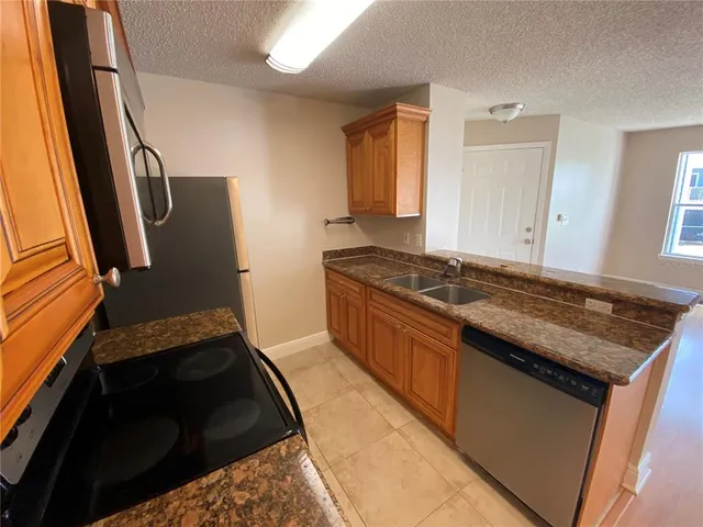 a kitchen with granite countertop a stove and a refrigerator