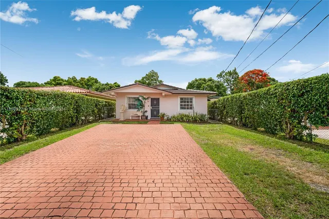 a front view of a house with a yard and potted plants