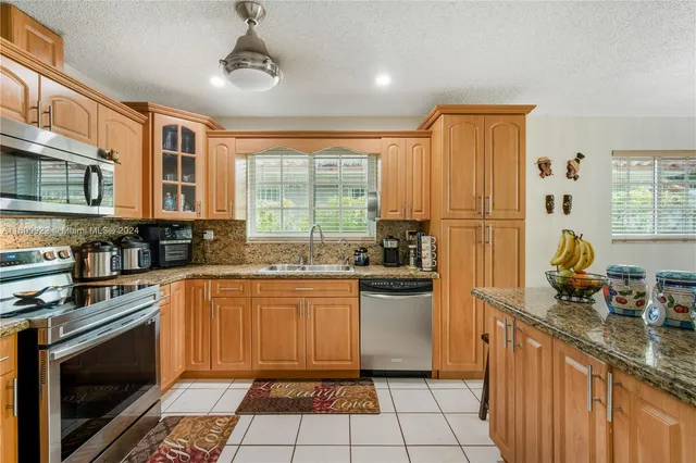 a kitchen with stainless steel appliances granite countertop a stove a sink and a microwave