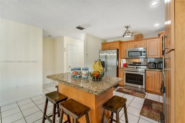 a kitchen with stainless steel appliances granite countertop a stove a sink a microwave and a refrigerator