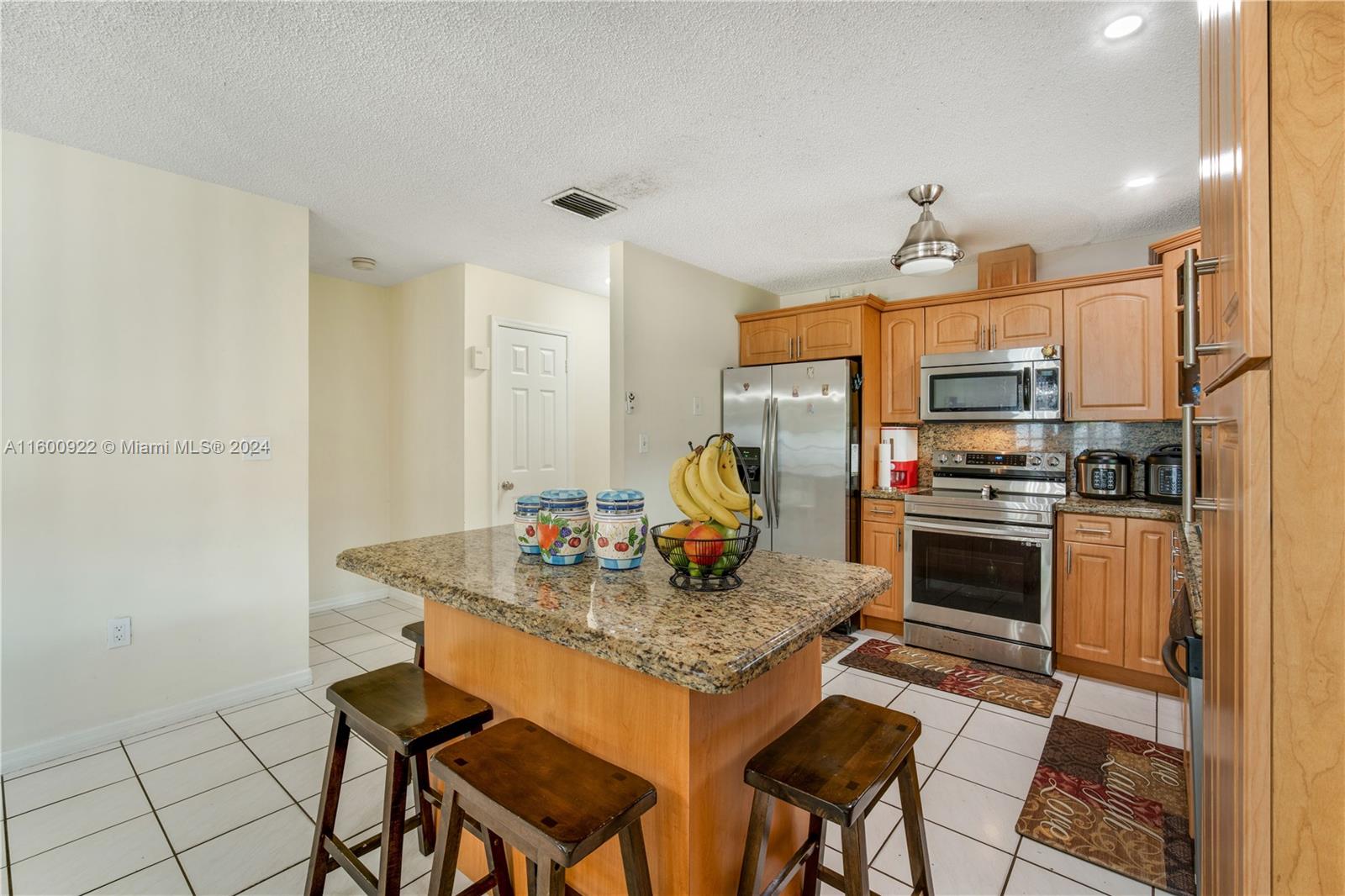 2245 Southwest 62nd Avenue Miami, FL 33155 - Photo 17 of 35 a kitchen with stainless steel appliances granite countertop a stove a sink a microwave and a refrigerator