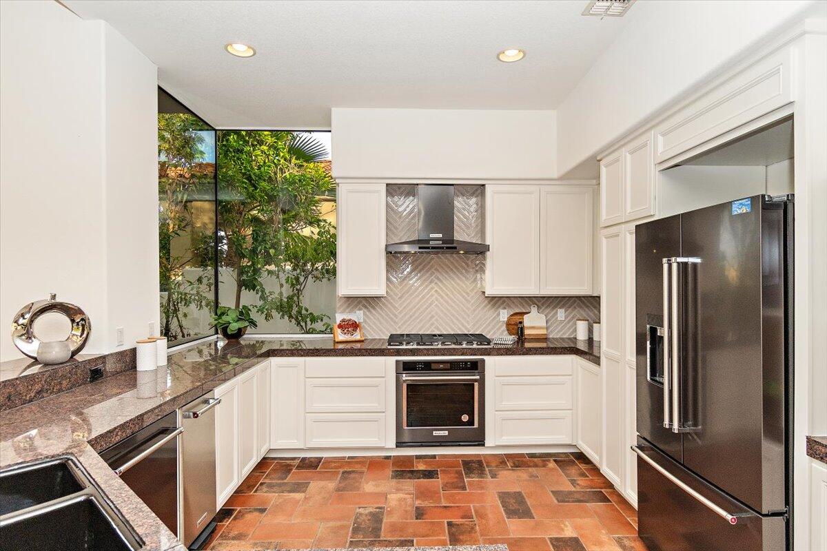 215 Loch Lomond Road Rancho Mirage, CA 92270 - Photo 11 of 57 a kitchen with a sink stove and refrigerator