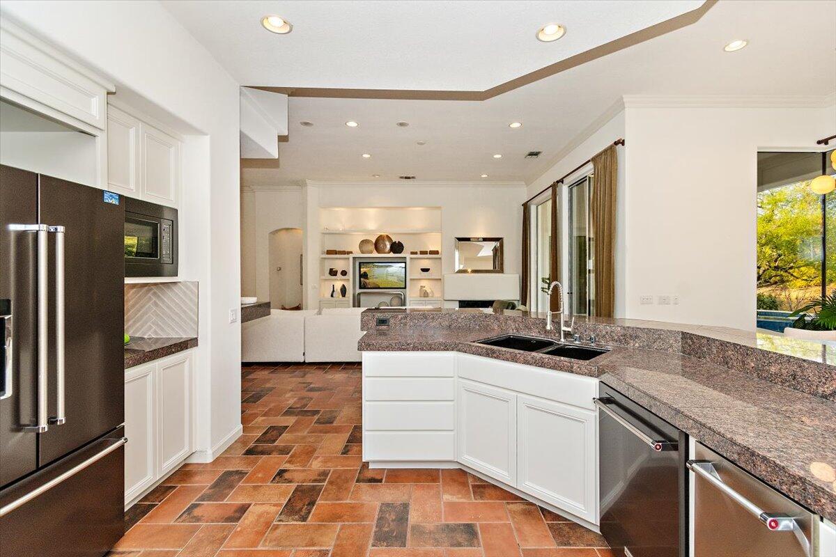215 Loch Lomond Road Rancho Mirage, CA 92270 - Photo 12 of 57 a kitchen with white cabinets and stainless steel appliances