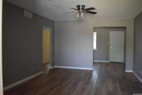 a view of room with hardwood floor and a ceiling fan