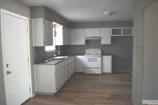 a kitchen with a sink a stove and cabinets