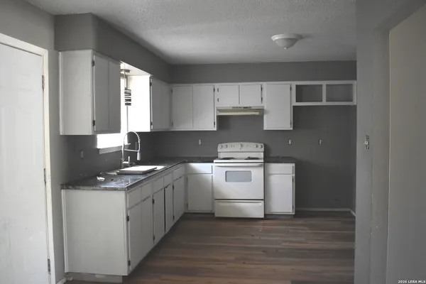a kitchen with a stove top oven sink and cabinets