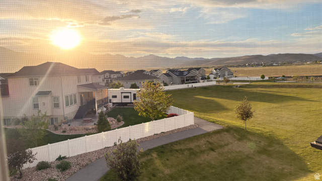 7889 Bristlecone Road Eagle Mountain, UT 84005 - Photo 42 of 42 Spacious backyard with a white privacy fence, mature trees, and a paved pathway