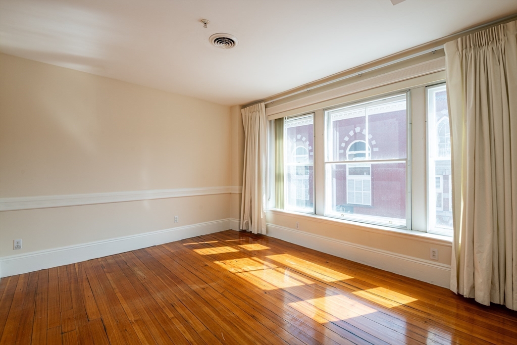 99 Washington Street, Unit 33 Salem, MA 01970 - Photo 16 of 36 an empty room with wooden floor and windows