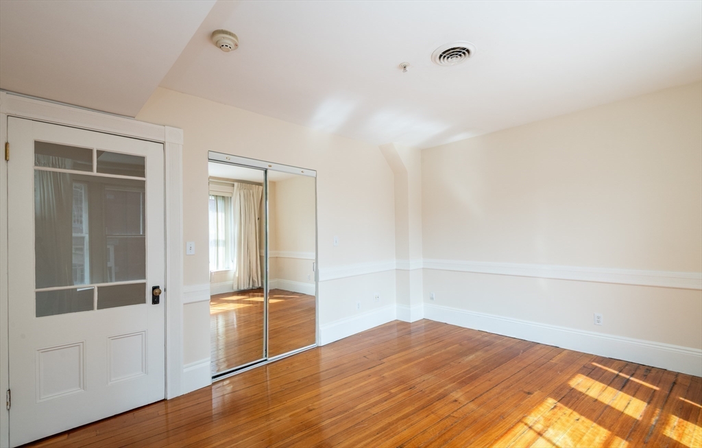 99 Washington Street, Unit 33 Salem, MA 01970 - Photo 19 of 36 an empty room with wooden floor and windows