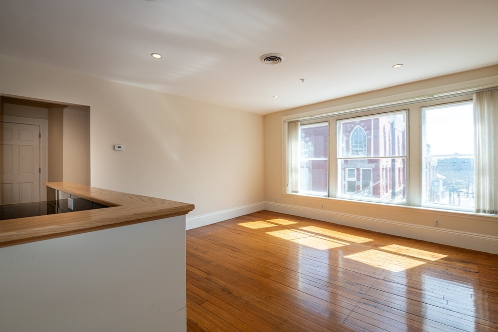 99 Washington Street, Unit 33 Salem, MA 01970 - Photo 22 of 36 a view of an empty room with window and wooden floor