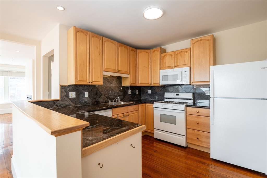 99 Washington Street, Unit 33 Salem, MA 01970 - Photo 24 of 36 a kitchen with granite countertop white cabinets and white appliances