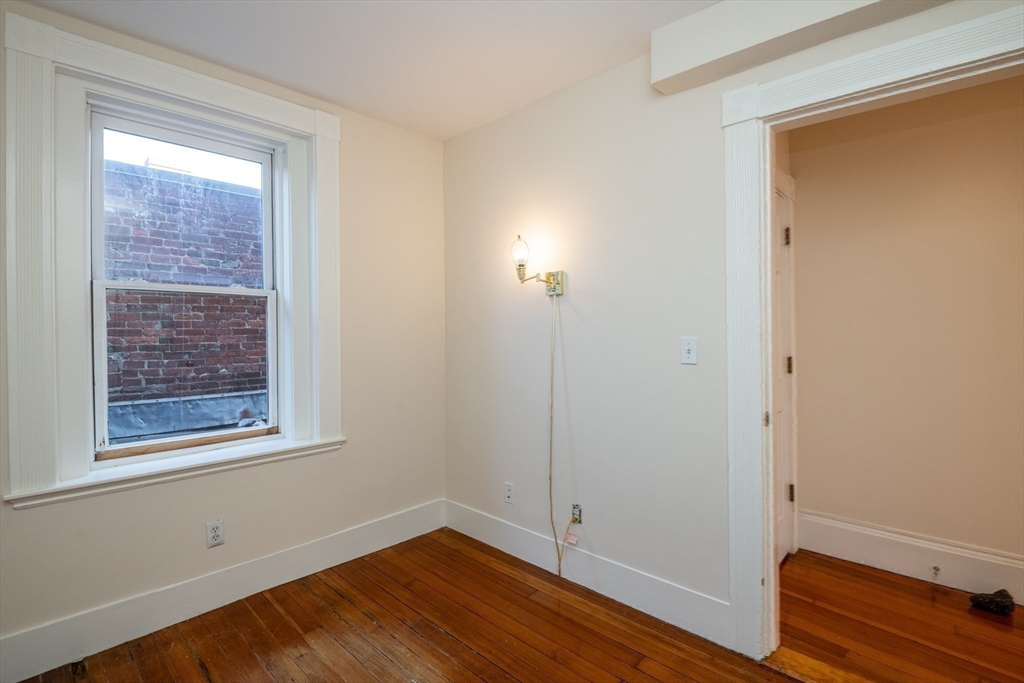 99 Washington Street, Unit 33 Salem, MA 01970 - Photo 31 of 36 an empty room with wooden floor and windows