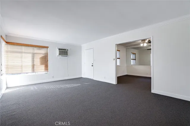 an empty room with windows and bathroom view