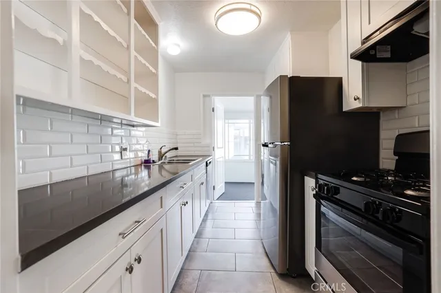 a kitchen with granite countertop a refrigerator and a sink