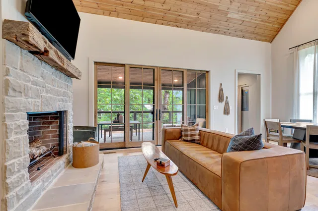a living room with fireplace furniture and a floor to ceiling window