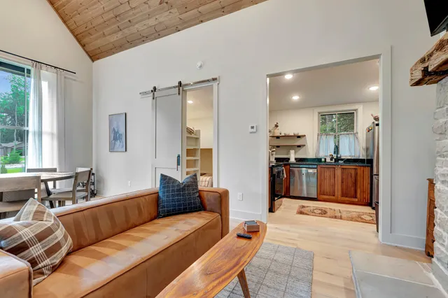 a living room with furniture and a view of kitchen