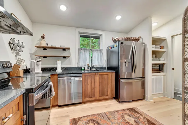 a kitchen with stainless steel appliances granite countertop a refrigerator and a sink