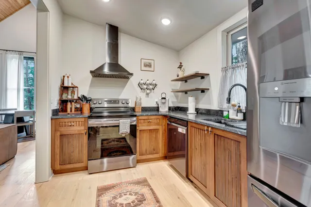 a kitchen with stainless steel appliances granite countertop a stove a sink and a refrigerator