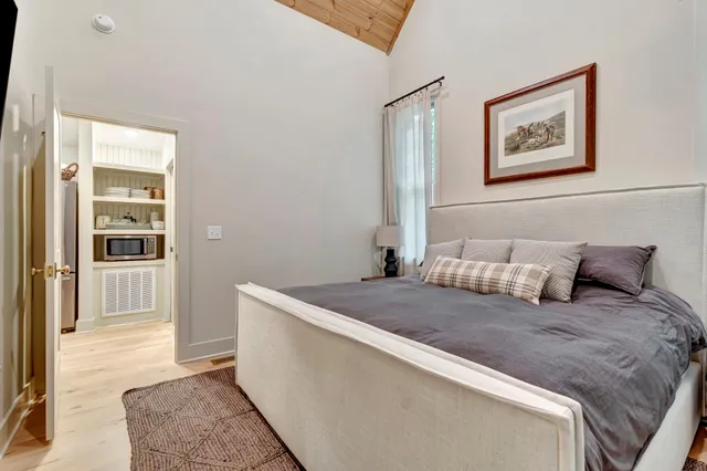 a large bed sitting in a bedroom next to a window