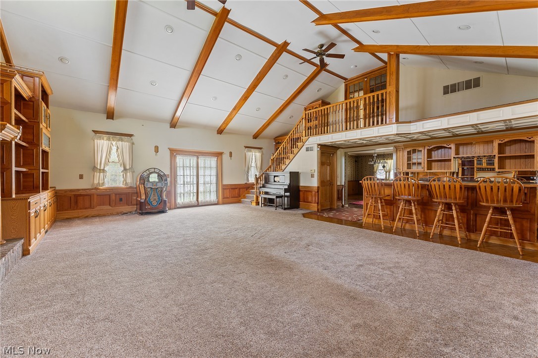 1815 Wick Campbell Road Hubbard, OH 44425 - Photo 12 of 43 Misc room featuring dark colored carpet, beamed ceiling, ceiling fan, bar area, and high vaulted ceiling