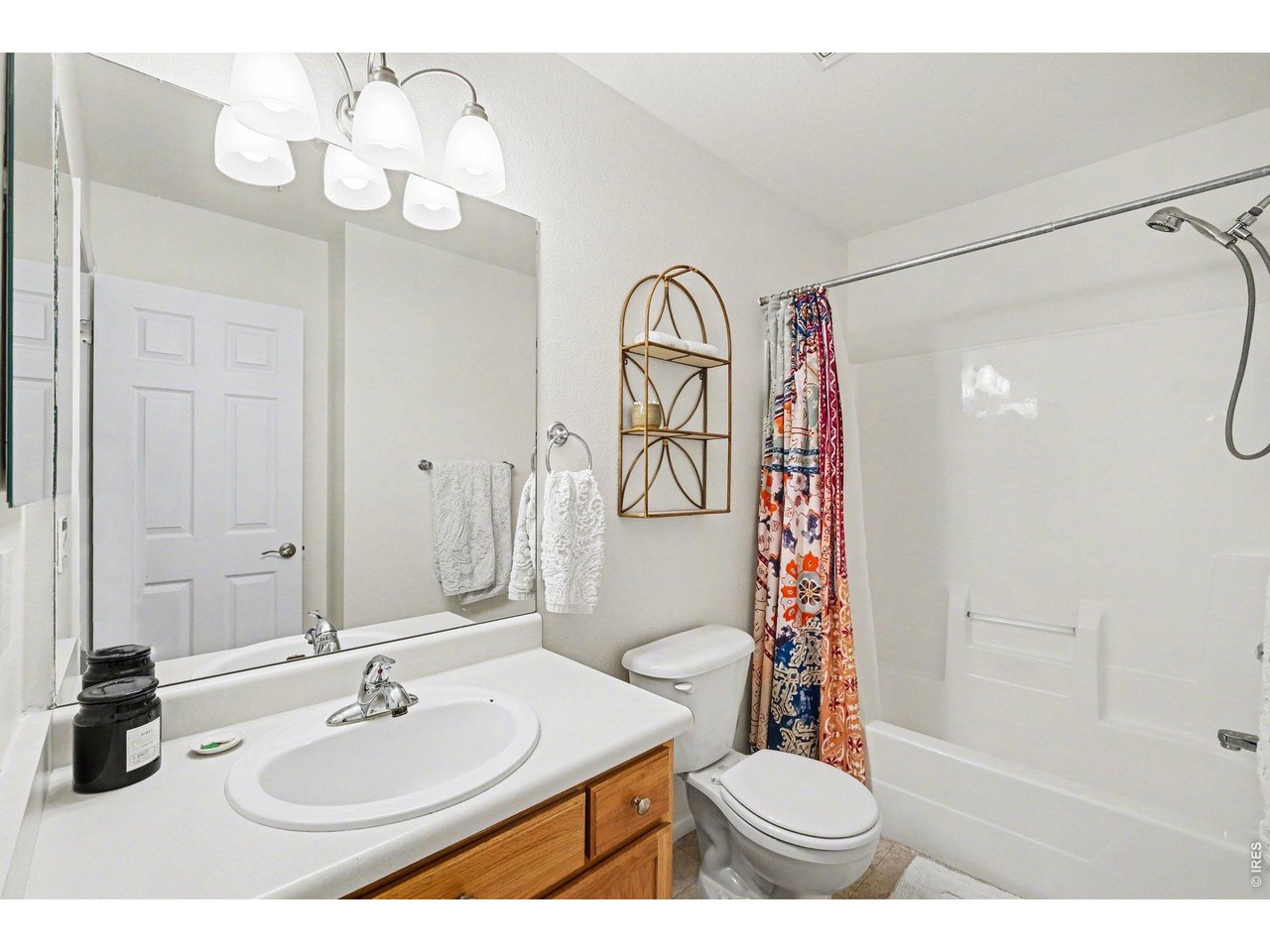 2702 Rigden Parkway, Unit 1 Fort Collins, CO 80525 - Photo 20 of 31 a bathroom with a sink a toilet a mirror a vanity and shower