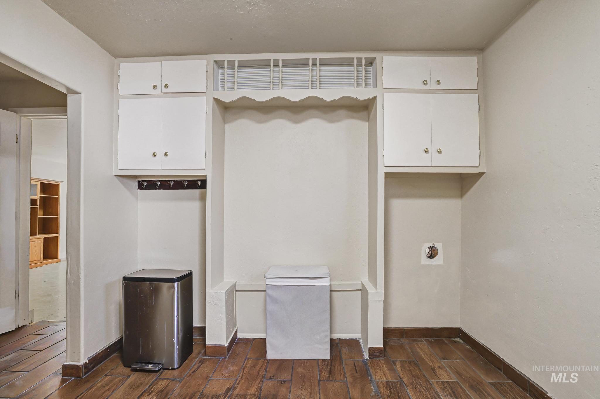 322 Jackson Street Twin Falls, ID 83301 - Photo 13 of 47 Laundry area featuring wood-finish flooring, white cabinetry, integrated shelving, and a dedicated appliance alcove with plumbing hookups