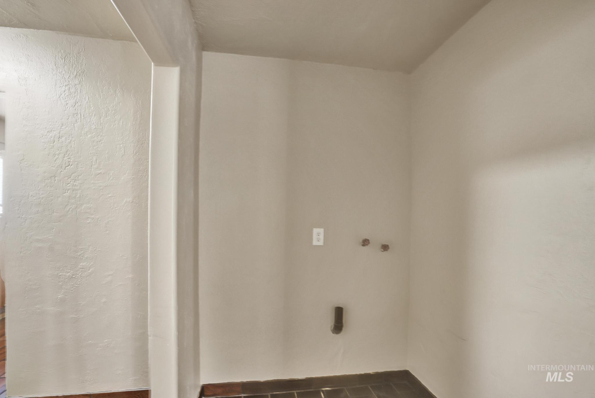 322 Jackson Street Twin Falls, ID 83301 - Photo 14 of 47 Utility area featuring dark tile flooring, neutral wall tones, and appliance hookups