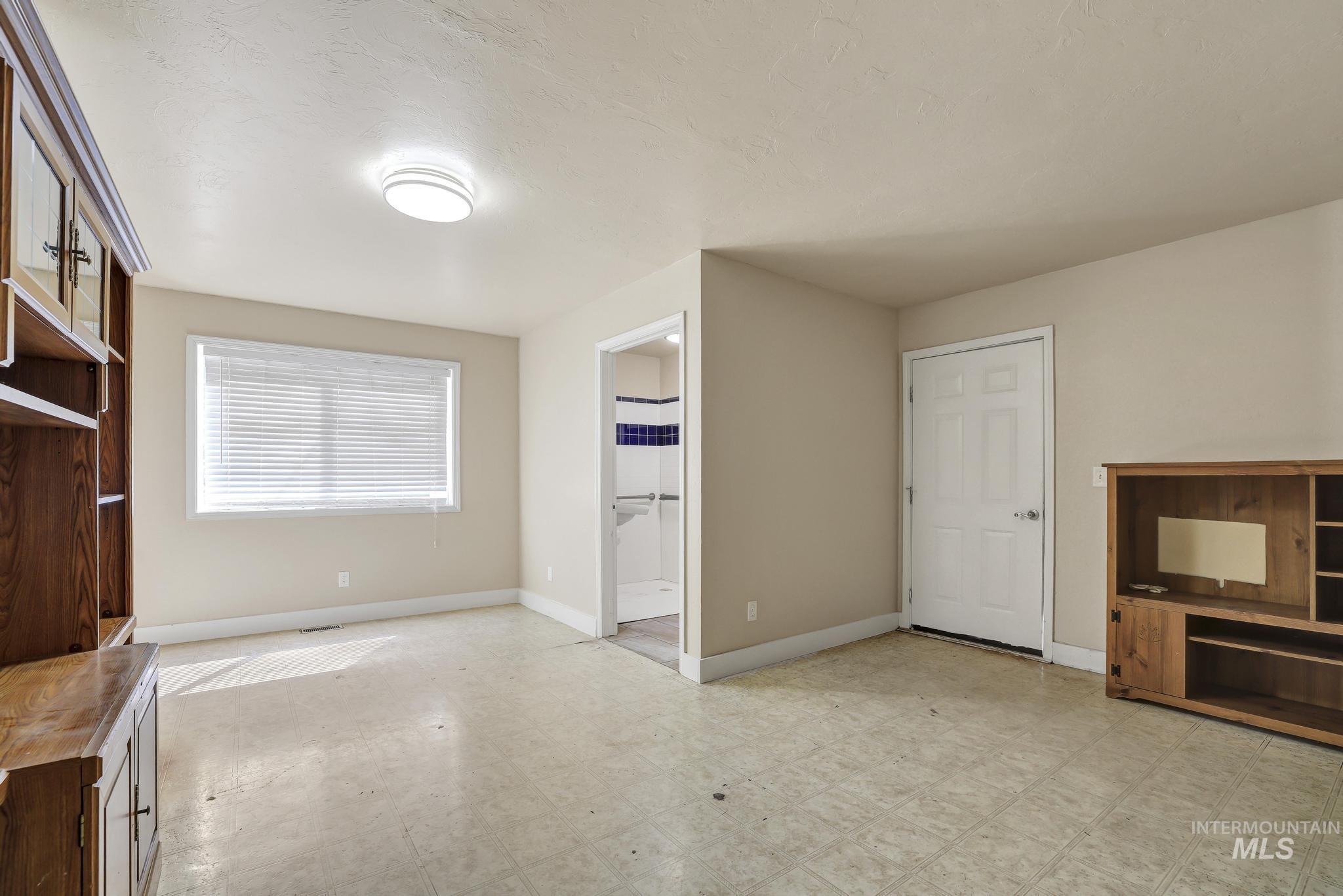 322 Jackson Street Twin Falls, ID 83301 - Photo 16 of 47 Spacious room featuring neutral painted walls, a window with horizontal blinds, and overhead ceiling lighting