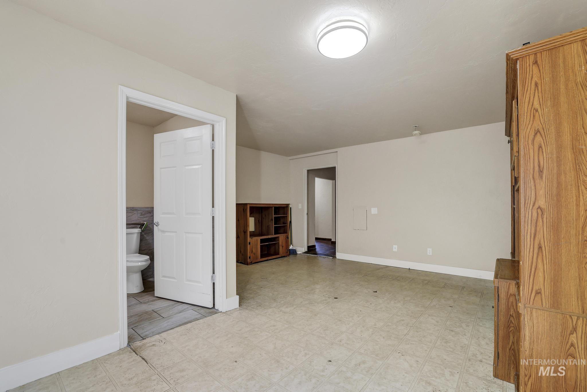 322 Jackson Street Twin Falls, ID 83301 - Photo 17 of 47 Spacious room featuring light-toned walls, tile flooring, and a flush-mount ceiling light fixture