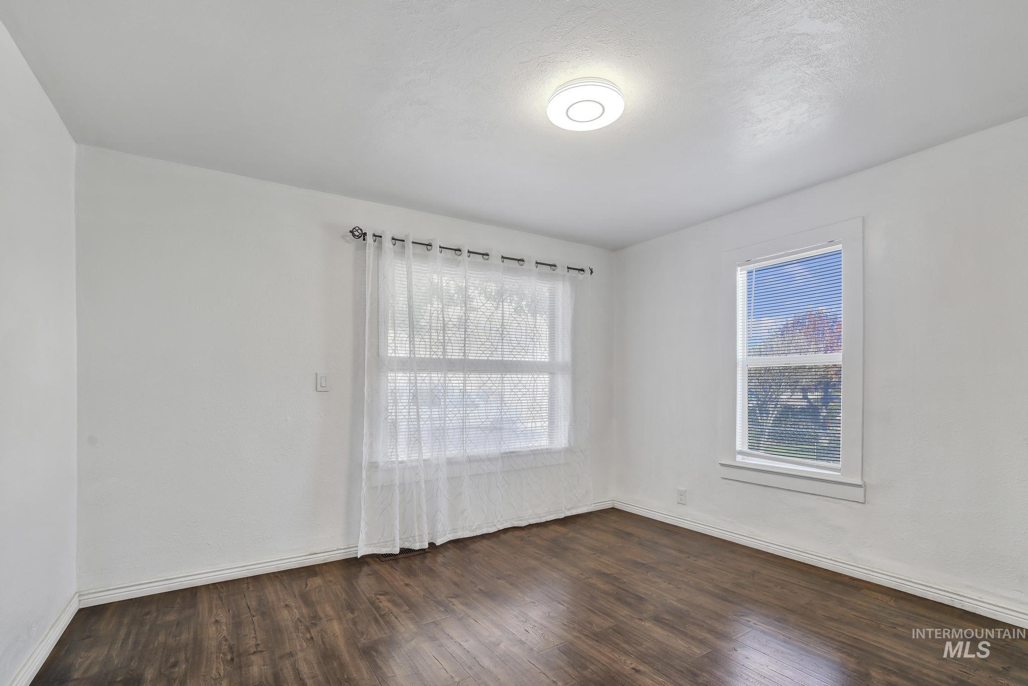 322 Jackson Street Twin Falls, ID 83301 - Photo 20 of 47 Bright interior space featuring wood-finish flooring, white baseboards, and a contemporary ceiling light fixture