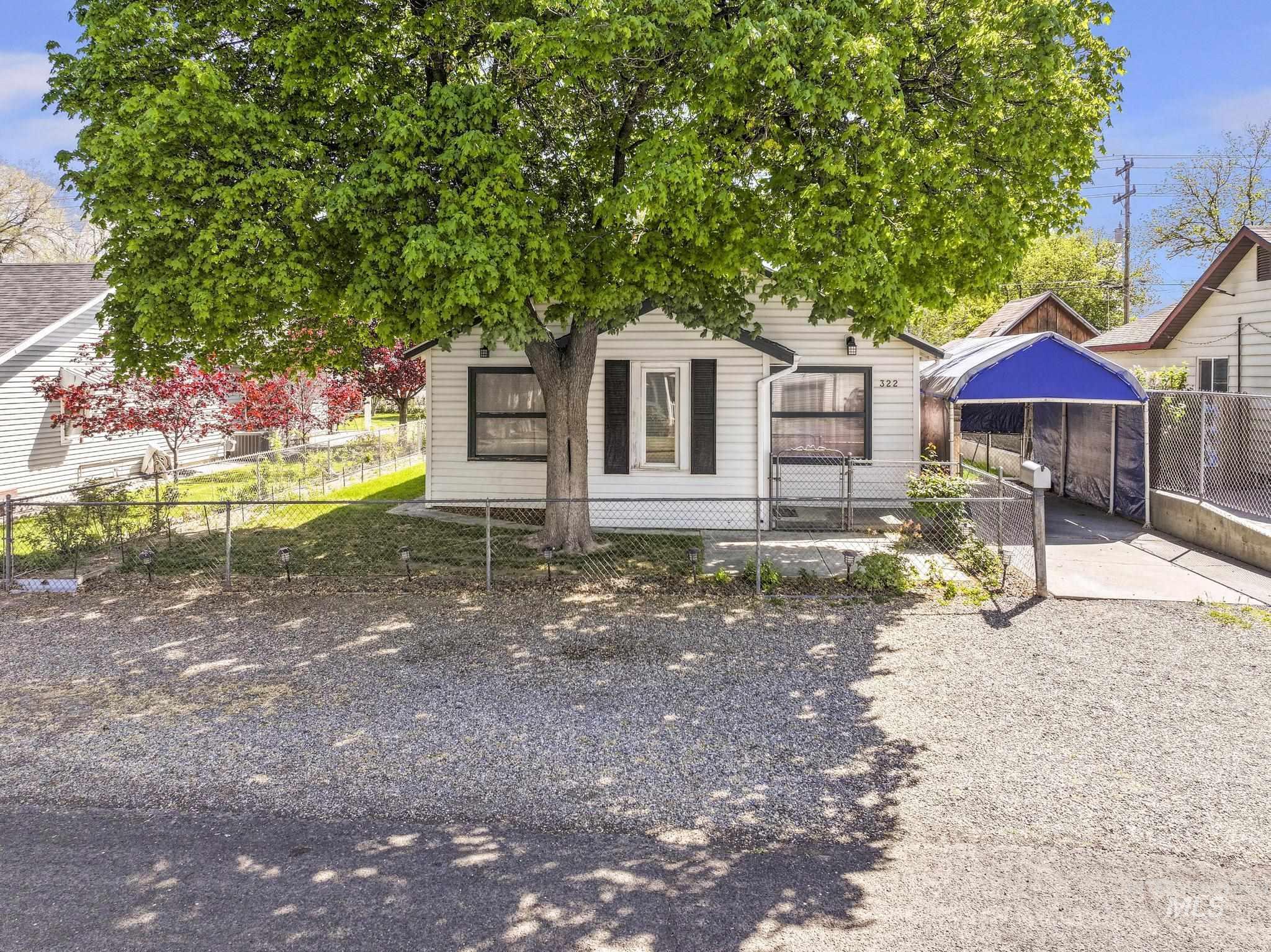 322 Jackson Street Twin Falls, ID 83301 - Photo 2 of 47 White siding residence with black window shutters and a mature deciduous tree in the front yard