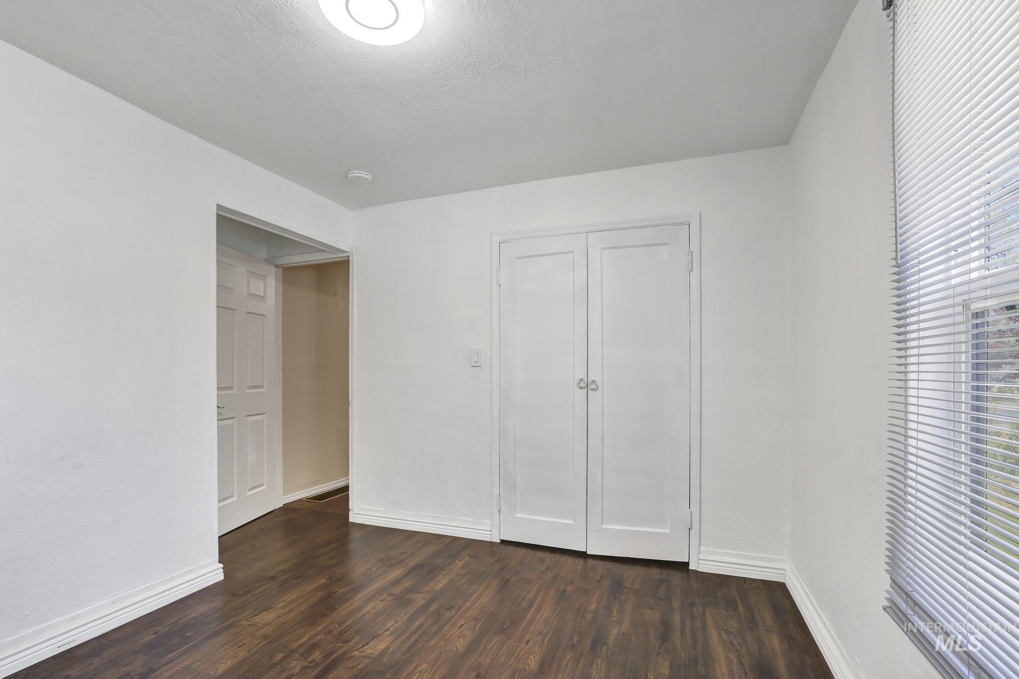322 Jackson Street Twin Falls, ID 83301 - Photo 24 of 47 Spacious room featuring wood-finish flooring, white walls, and a ceiling-mounted light fixture