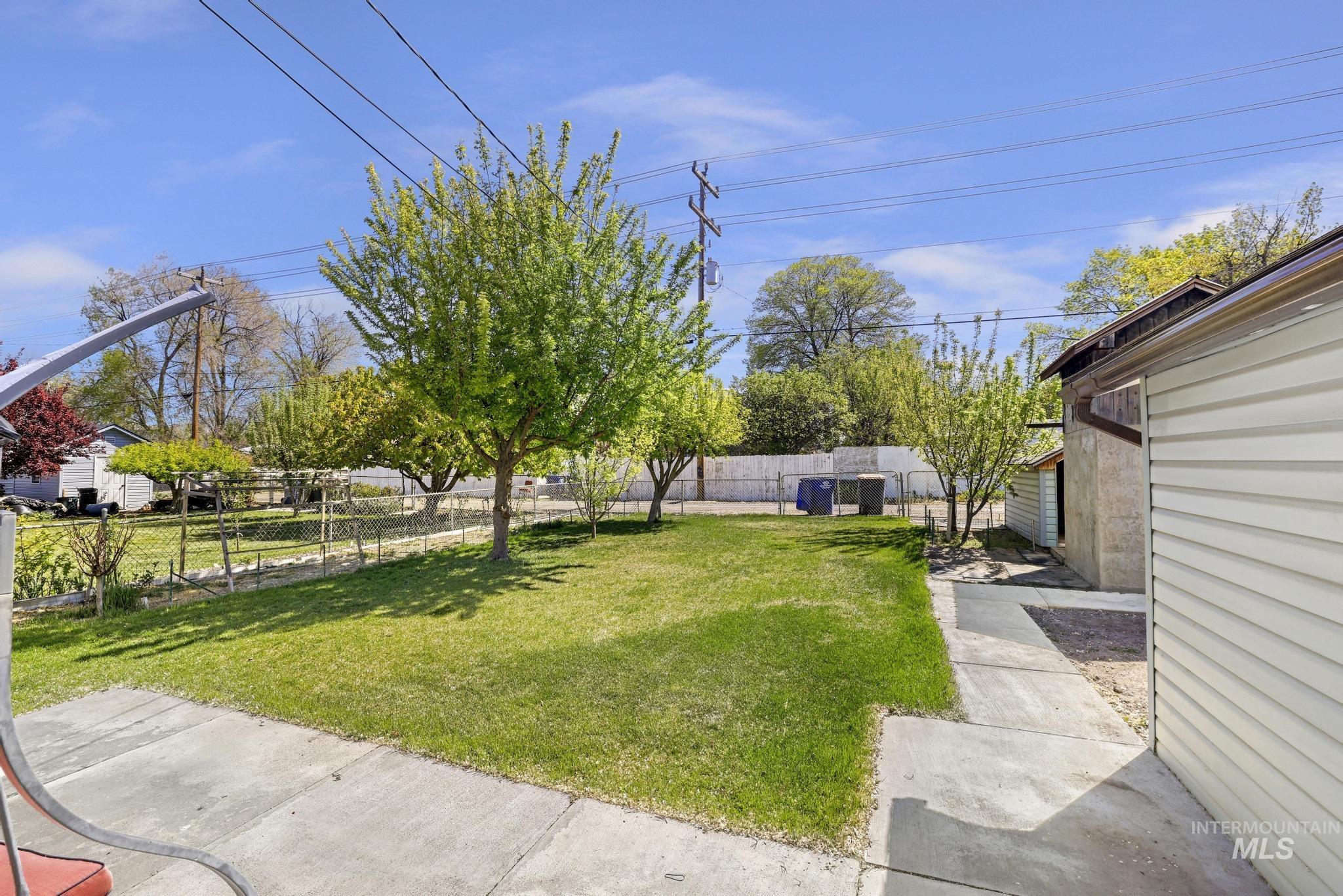 322 Jackson Street Twin Falls, ID 83301 - Photo 25 of 47 Expansive backyard featuring a manicured lawn, mature trees, and a chain-link fence
