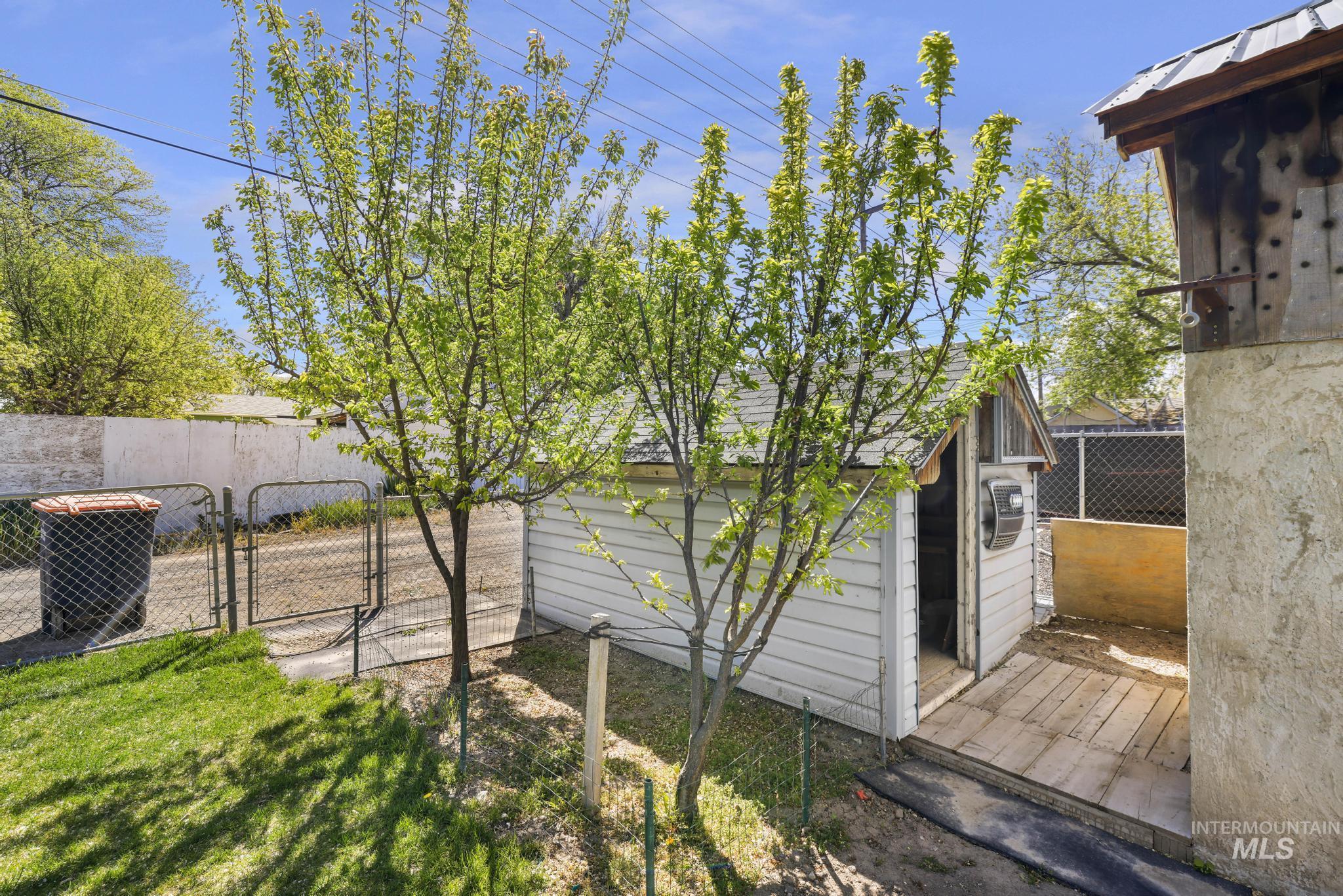 322 Jackson Street Twin Falls, ID 83301 - Photo 28 of 47 Grassy yard area featuring mature trees and a chain-link fence