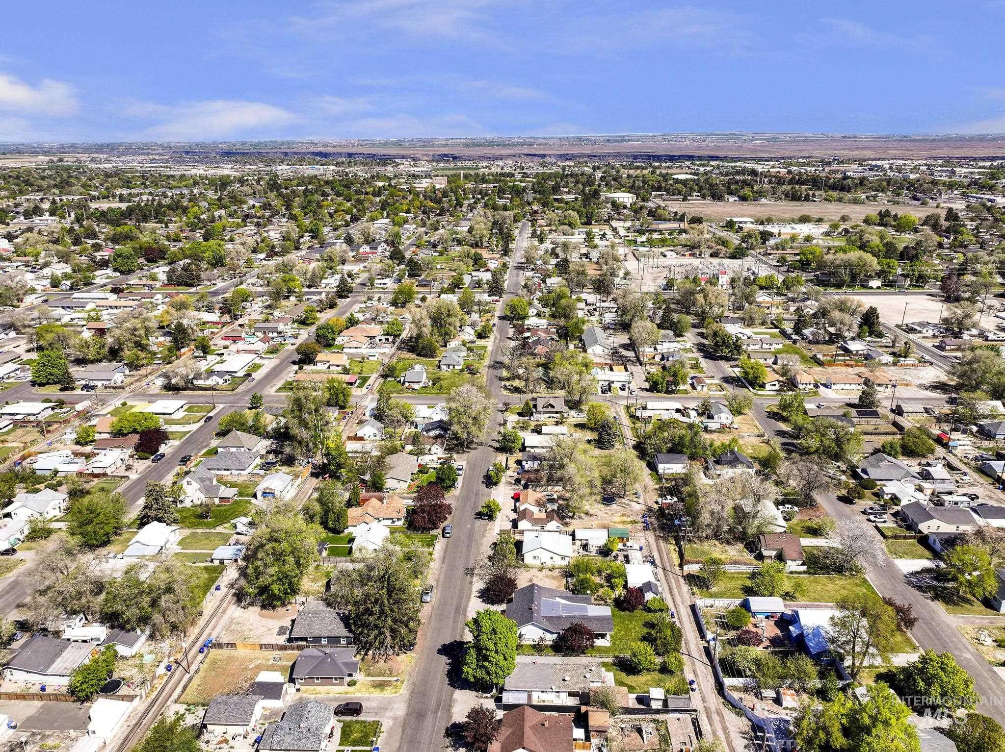 322 Jackson Street Twin Falls, ID 83301 - Photo 40 of 47 Expansive aerial view showcasing a developed residential area with numerous single-story homes, mature deciduous trees, paved streets, and abundant green space
