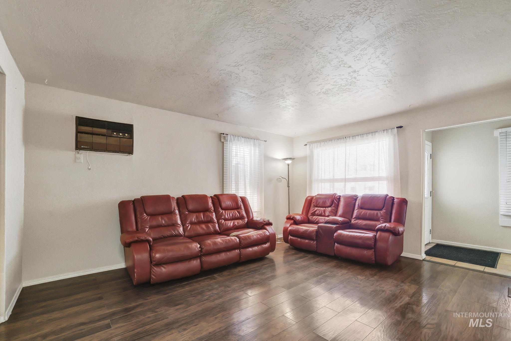 322 Jackson Street Twin Falls, ID 83301 - Photo 6 of 47 Spacious living area featuring wood-finish flooring, light-colored walls, and abundant natural light from multiple windows
