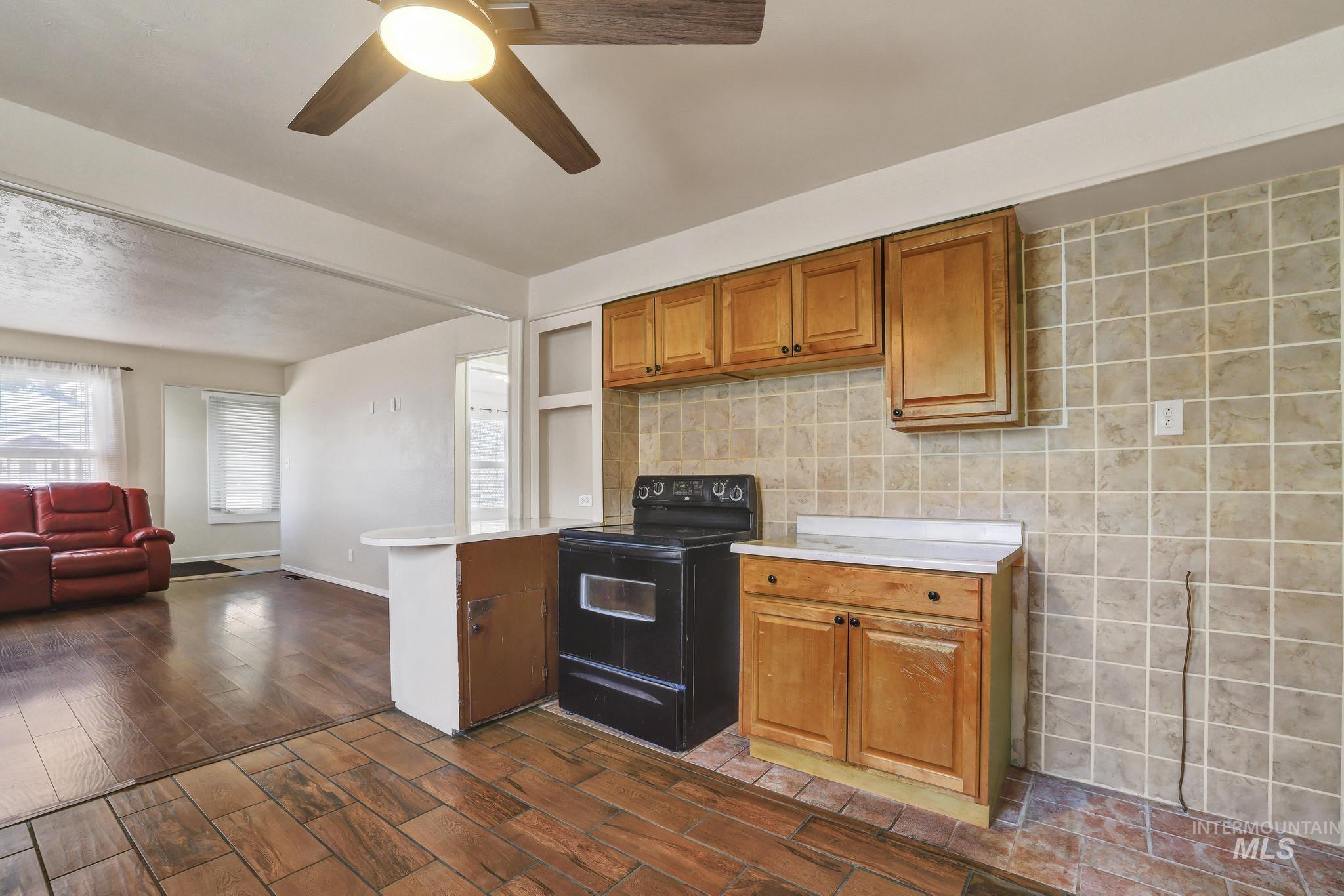322 Jackson Street Twin Falls, ID 83301 - Photo 10 of 47 Kitchen area featuring wood-finish cabinetry, a freestanding range, and tiled flooring