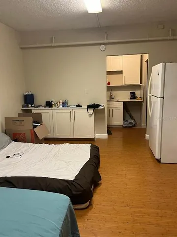 a kitchen with a refrigerator and white cabinets
