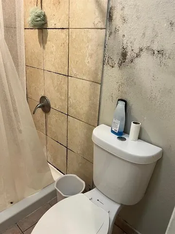 a bathroom with a toilet and a shower