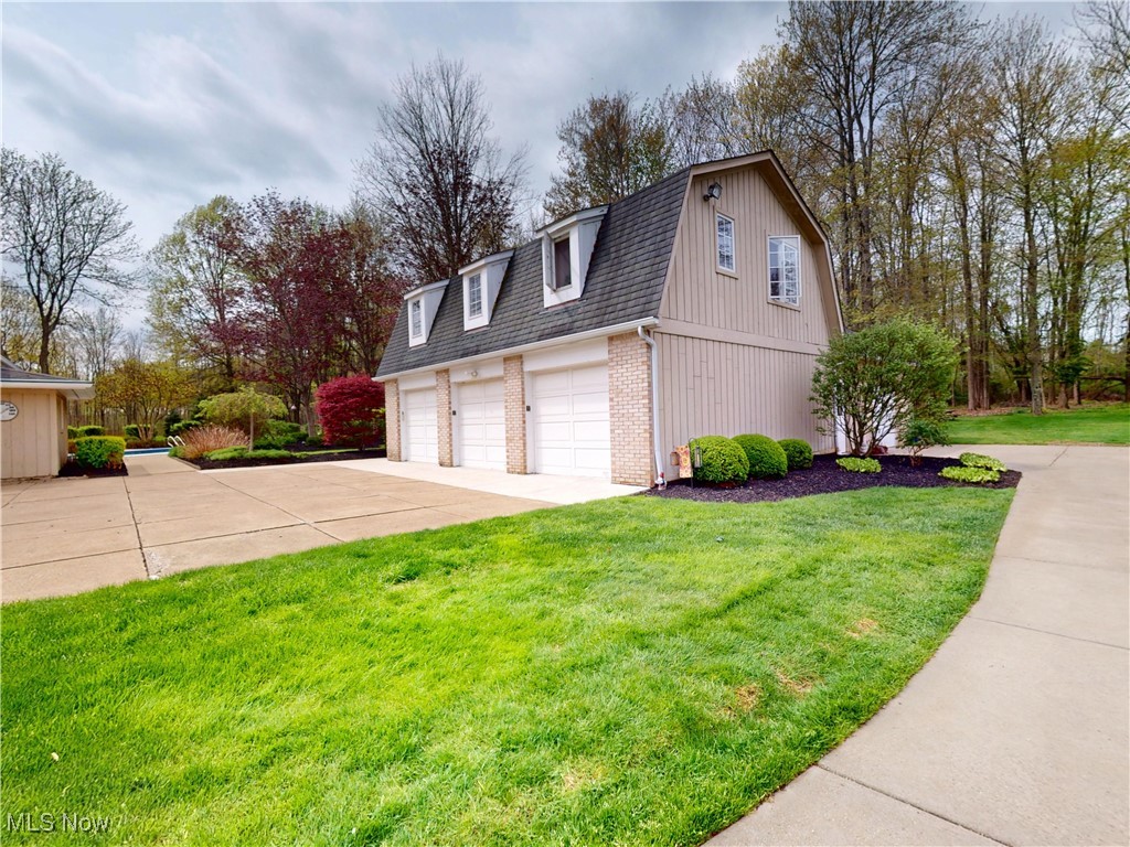 9870 Hobart Road Willoughby, OH 44094 - Photo 46 of 50 View of property exterior featuring a shingled roof, a gambrel roof, brick siding, concrete driveway, and a yard