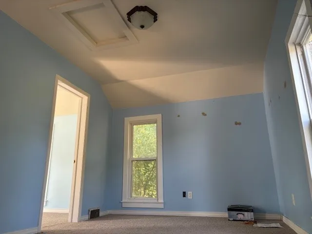 an empty room with wooden floor and mirror