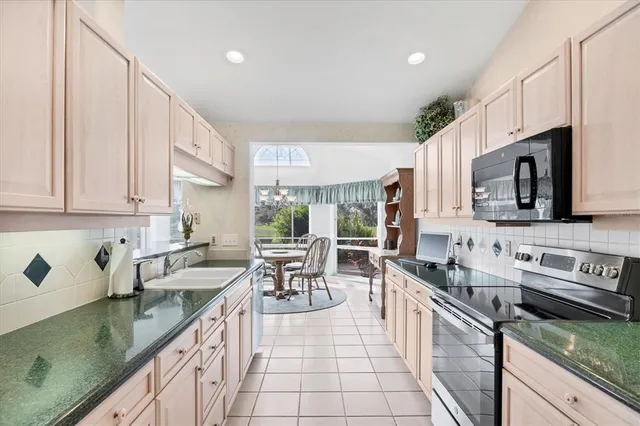 a kitchen with stainless steel appliances granite countertop a sink stove and cabinets